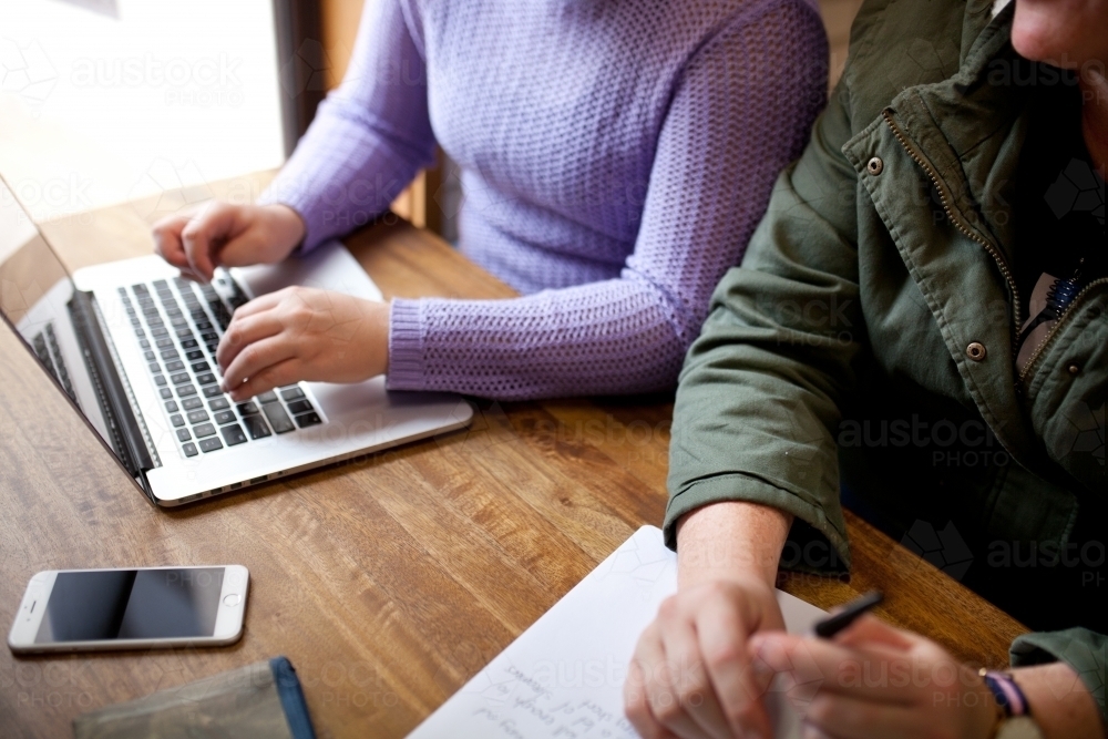 Two young people sitting at a desk in a classroom - Australian Stock Image