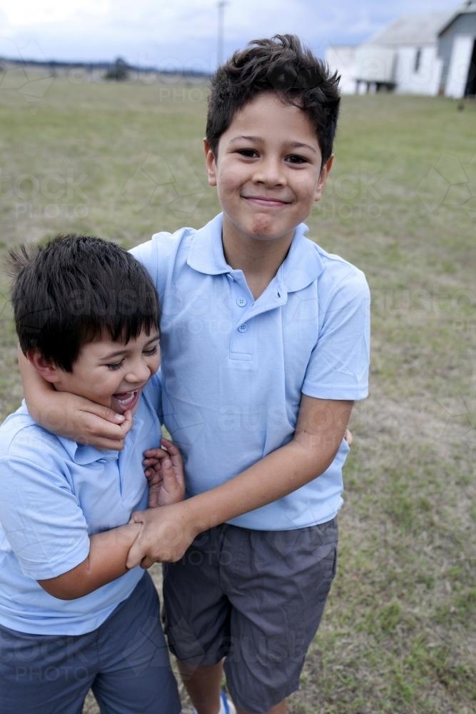 Two young school boys playing around outside - Australian Stock Image