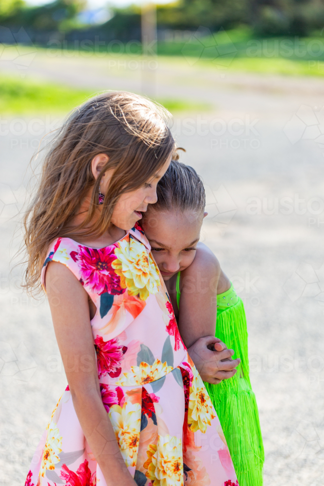 Two young Torres Strait Islander cousins hugging each other under the sun - Australian Stock Image