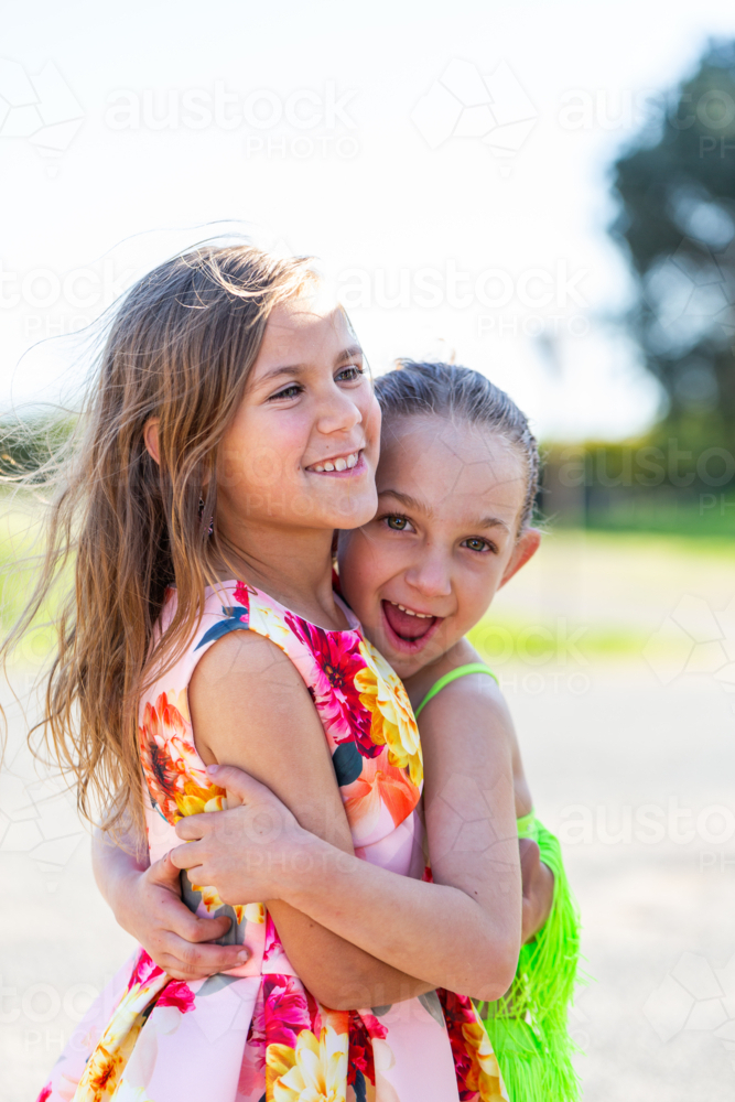 Two young Torres Strait Islander cousins hugging each other under the sun - Australian Stock Image