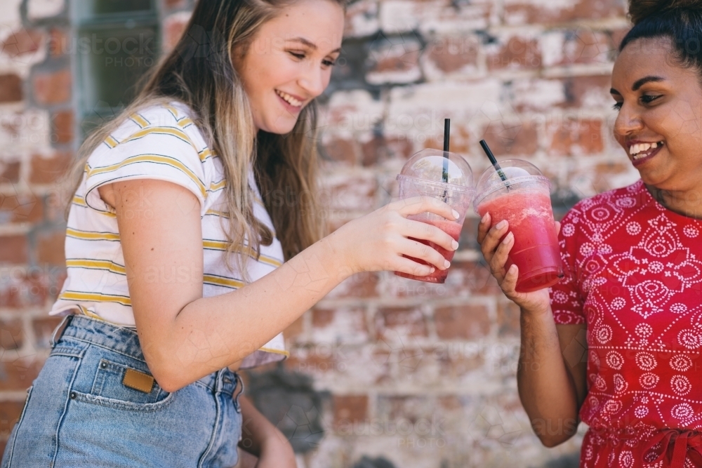 two young women drinking smoothies - Australian Stock Image