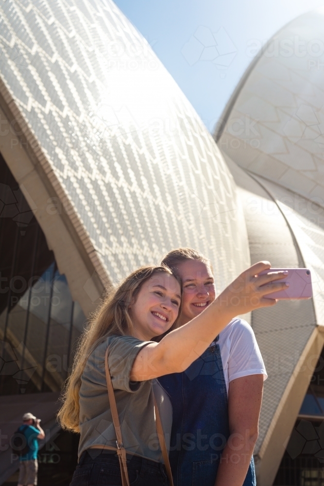 two young women posing in front of Sydney Opera House - Australian Stock Image