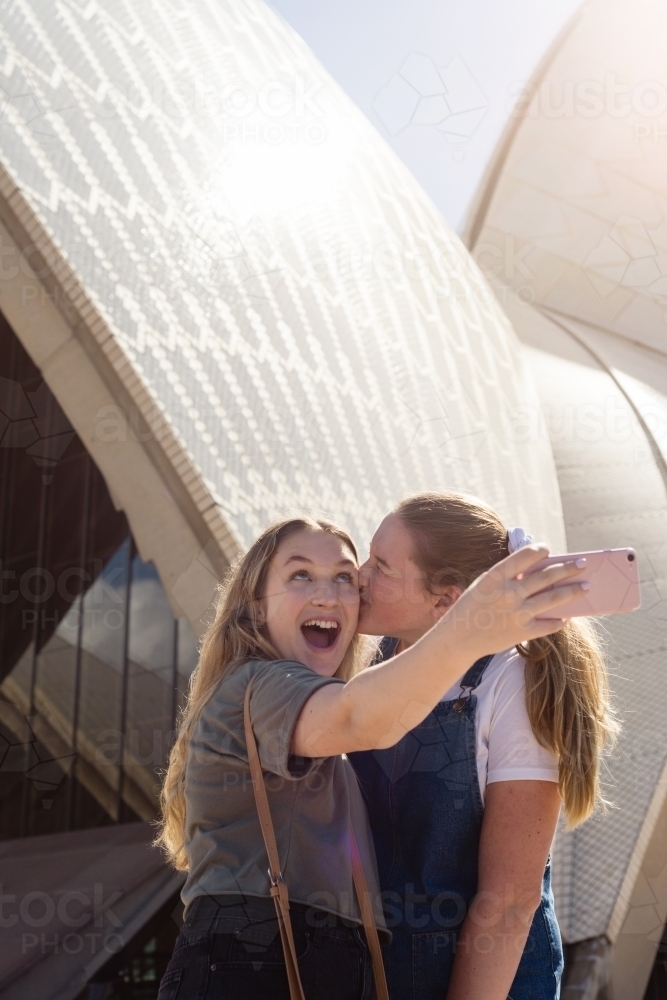 two young women posing in front of Sydney Opera House - Australian Stock Image