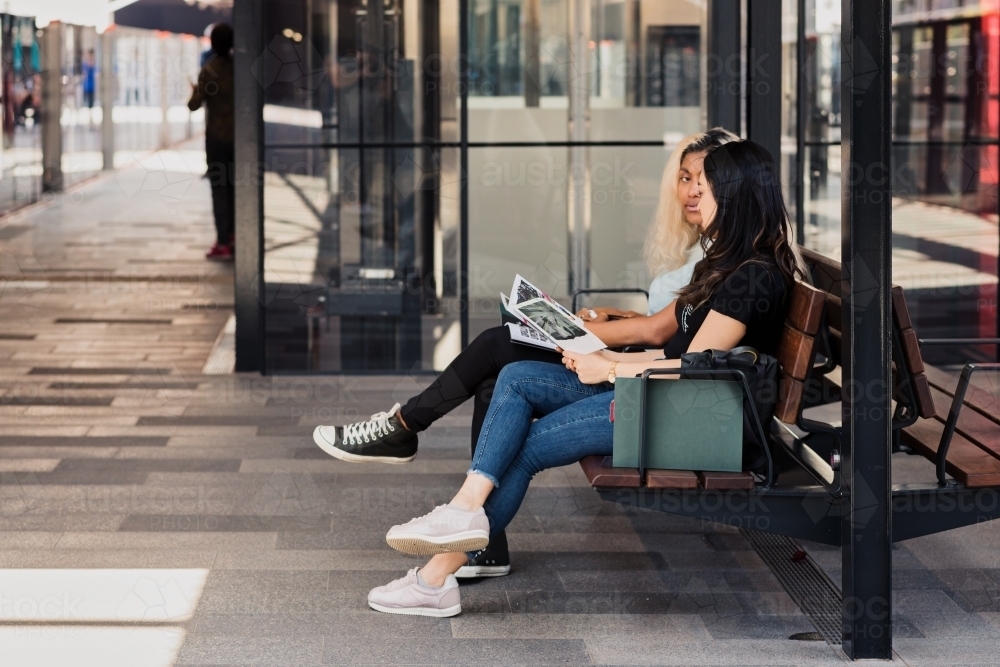 two young women waiting at the train station - Australian Stock Image
