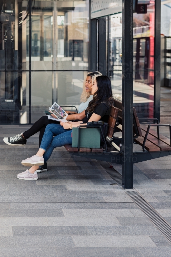 two young women waiting at the train station - Australian Stock Image