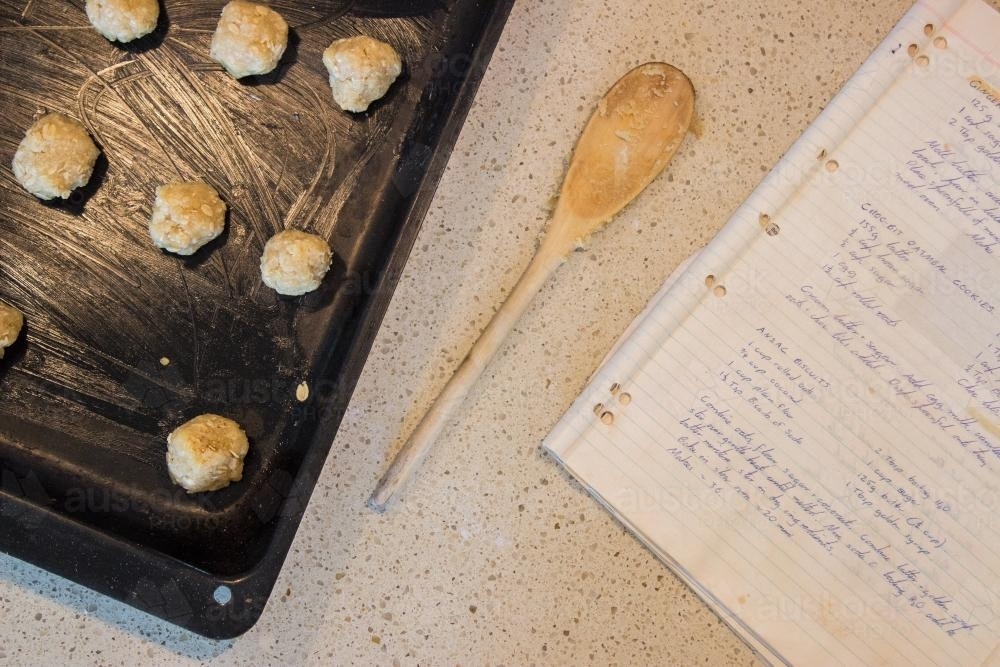 Uncooked ANZAC biscuits and handwritten recipe book - Australian Stock Image