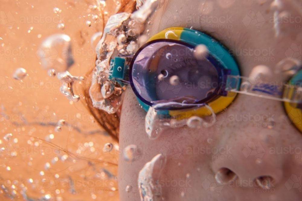 Underwater close up of girl wearing goggles - Australian Stock Image