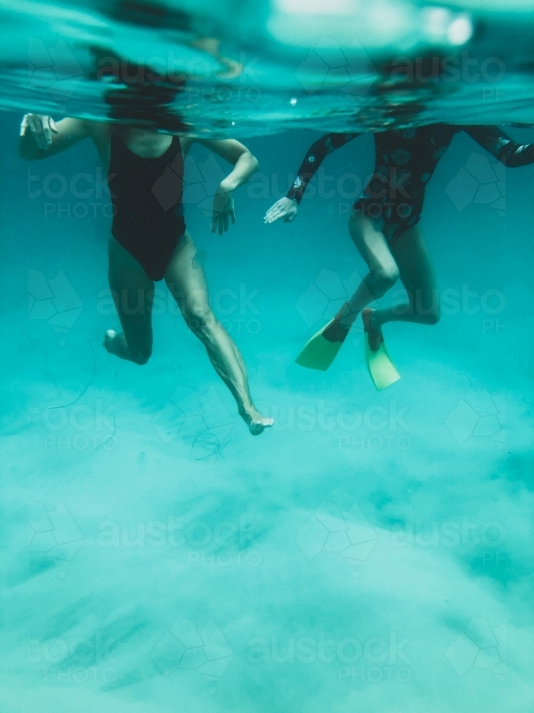 Underwater of two females bodies treading water in ocean - Australian Stock Image