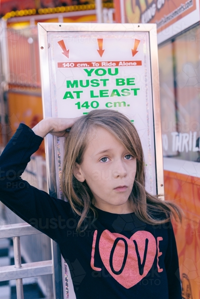 unhappy child, not tall enough to go on the rides at the funfair - Australian Stock Image