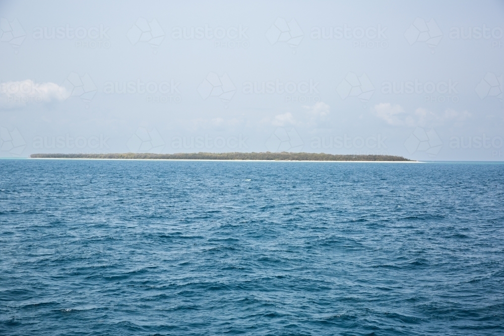 Image of uninhabited island on the Great Barrier Reef on a sunny day Austockphoto