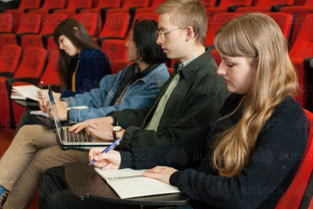 university students taking notes in lecture theatre - Australian Stock Image