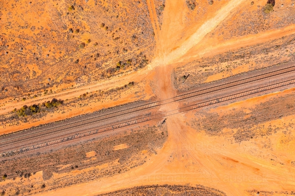 unsealed road crossing the Trans Australian railway line in Central Australia - Australian Stock Image