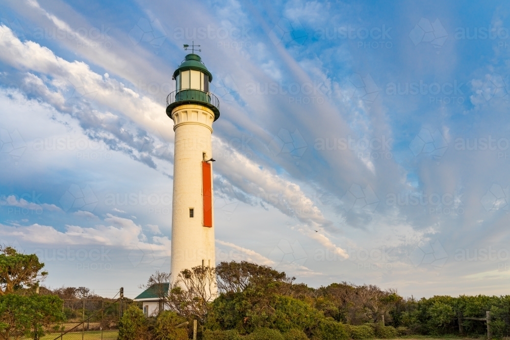 Unusual cloud formation over a tall lighthouse - Australian Stock Image
