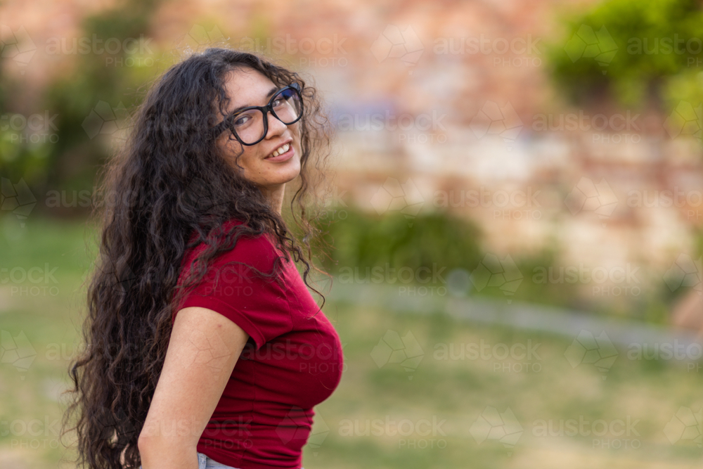 upper body shot of teen girl with long black hair cascading down her back - Australian Stock Image