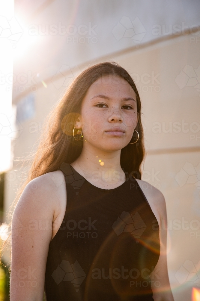 urban sunflare over mixed race teen girl - Australian Stock Image