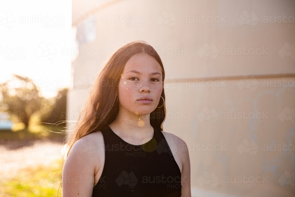 urban sunflare over mixed race teen girl with copy space - Australian Stock Image