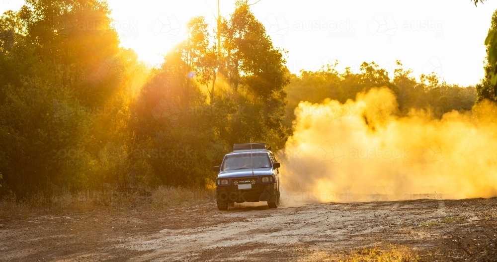 ute doing brodies on dirt track with dust billowing behind - Australian Stock Image