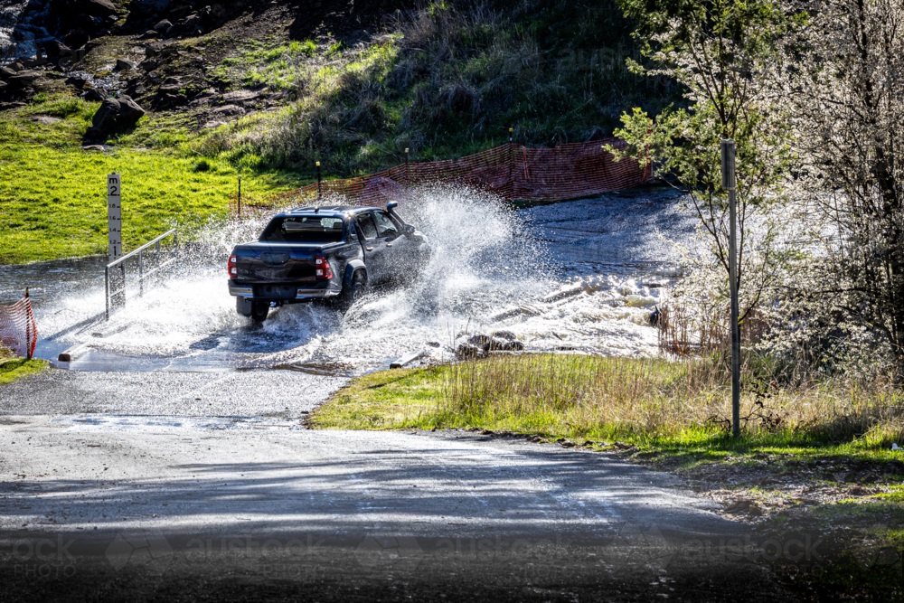 Ute driving across floodway in regional Australia - Australian Stock Image