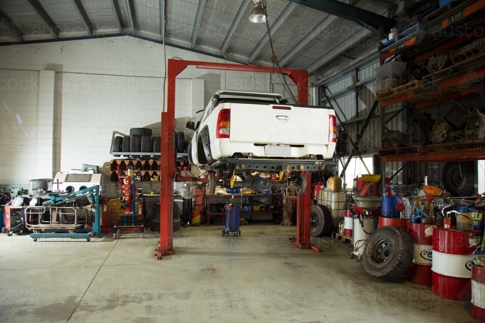 Ute raised for repairs in a mechanic workshop - Australian Stock Image