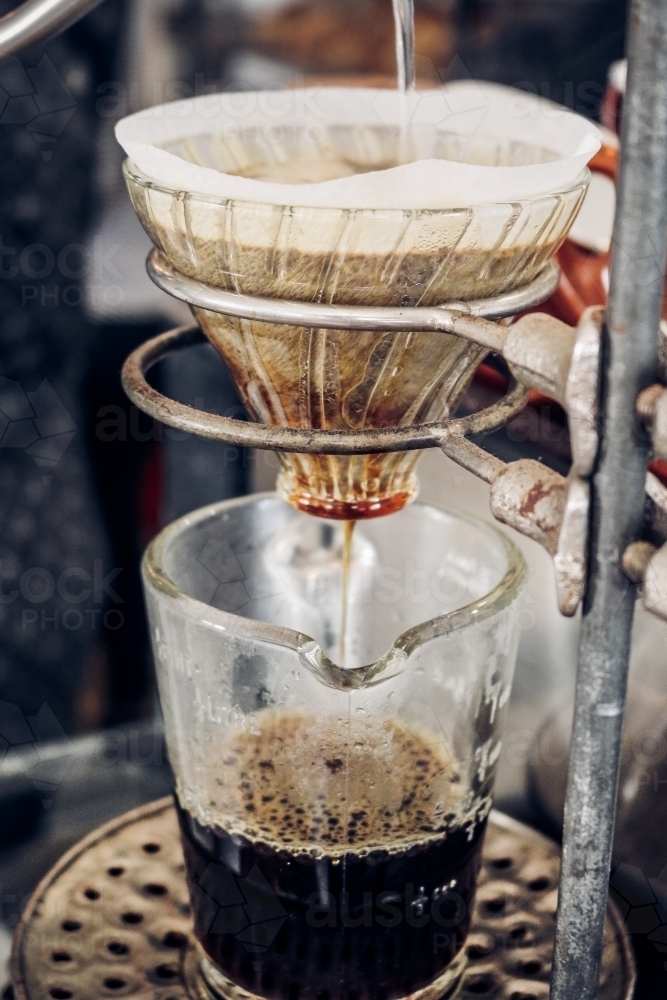 V60 filter coffee dripping into glass jug from left perspective - Australian Stock Image