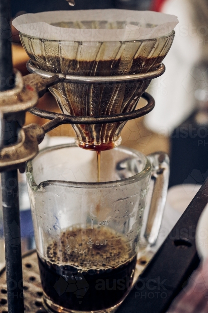 V60 filter coffee dripping into glass jug from right perspective - Australian Stock Image