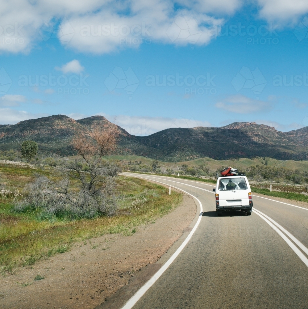 Van driving along a rural outback road from behind - Australian Stock Image
