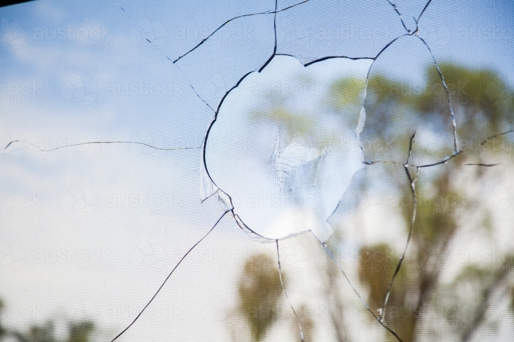 Vandalized window of building, smashed broken glass - Australian Stock Image