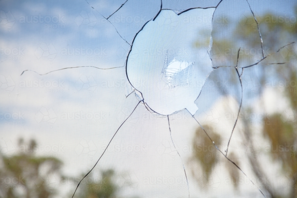 Vandalized window of building, smashed broken glass - Australian Stock Image