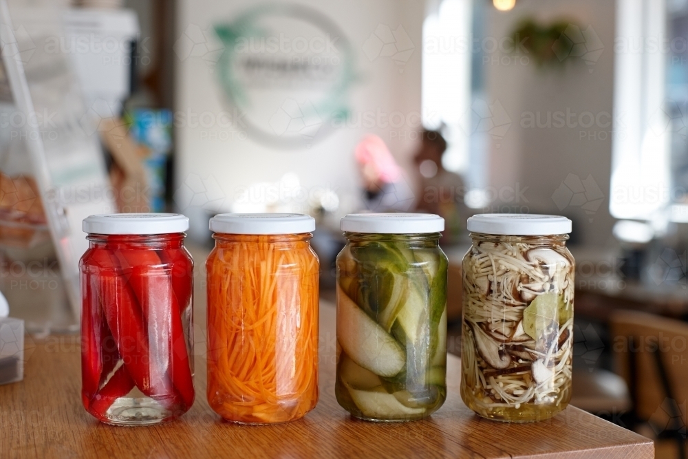 Image of Variety of pickle jars lined up on counter in cafe Austockphoto