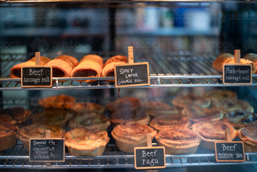 various hot pastries in a warm oven in a bakery - Australian Stock Image