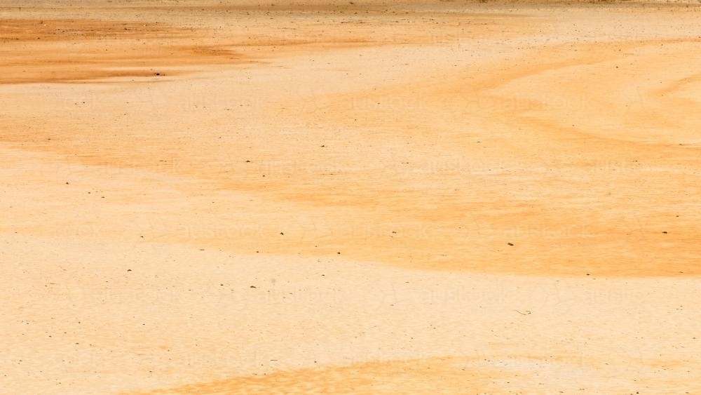 Varying shades of yellow and orange swirls in desert claypans - Australian Stock Image