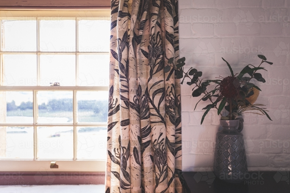 Vase next to window overlooking landscape - Australian Stock Image