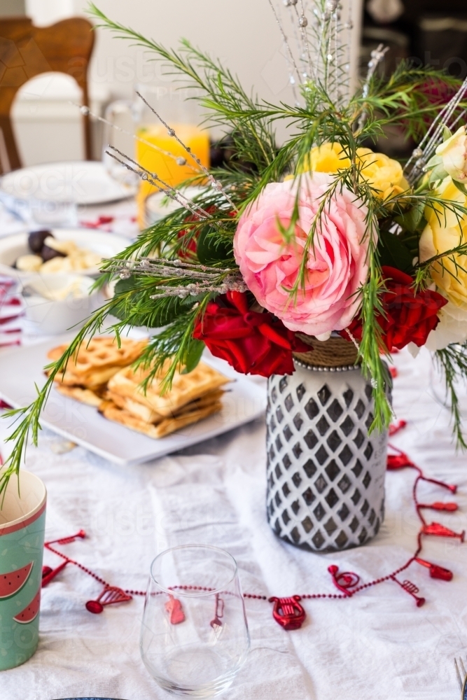 vase of flowers on a breakfast table - Australian Stock Image