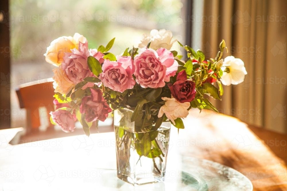Vase of roses fresh from the garden on the table - Australian Stock Image