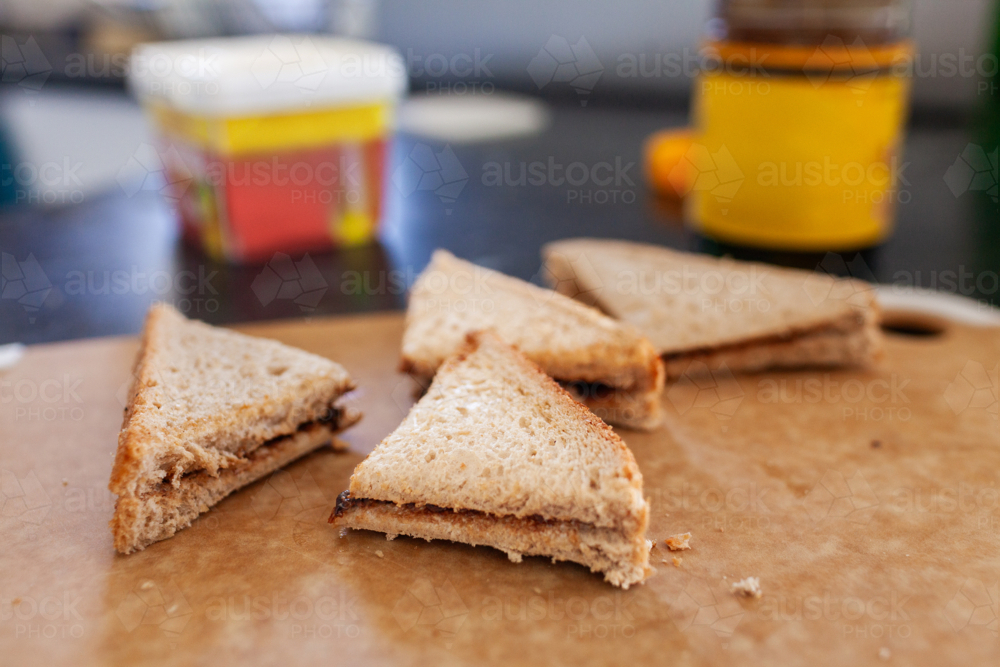 Vegemite sandwich triangles on cutting board on kitchen bench in Australia ready for morning tea - Australian Stock Image