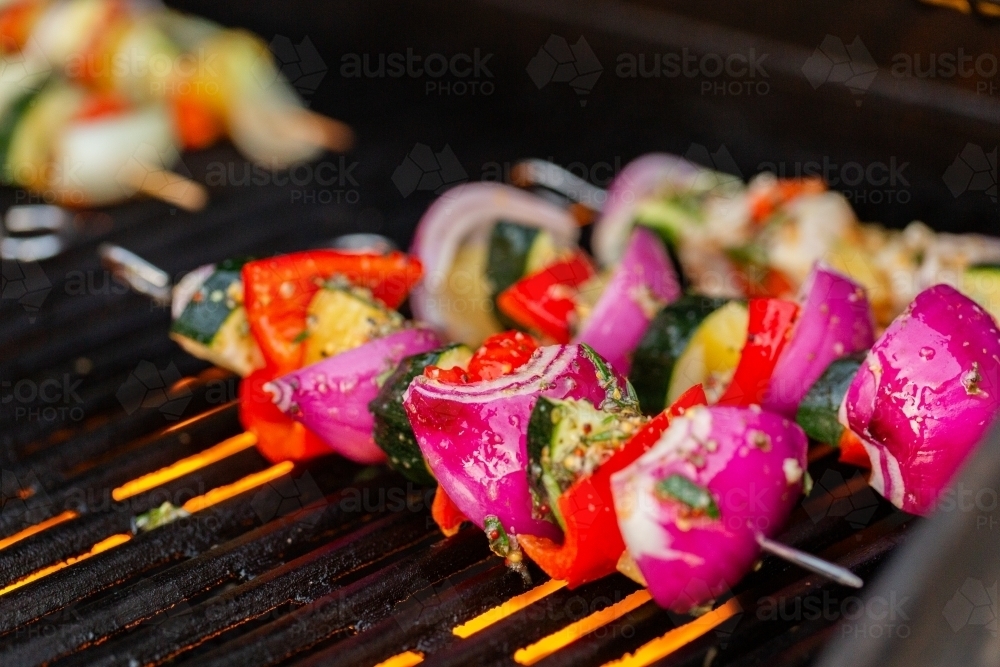Veggie kebabs cooking on BBQ grill for dinner made with onion, capsicum, pineapple and zucchini - Australian Stock Image
