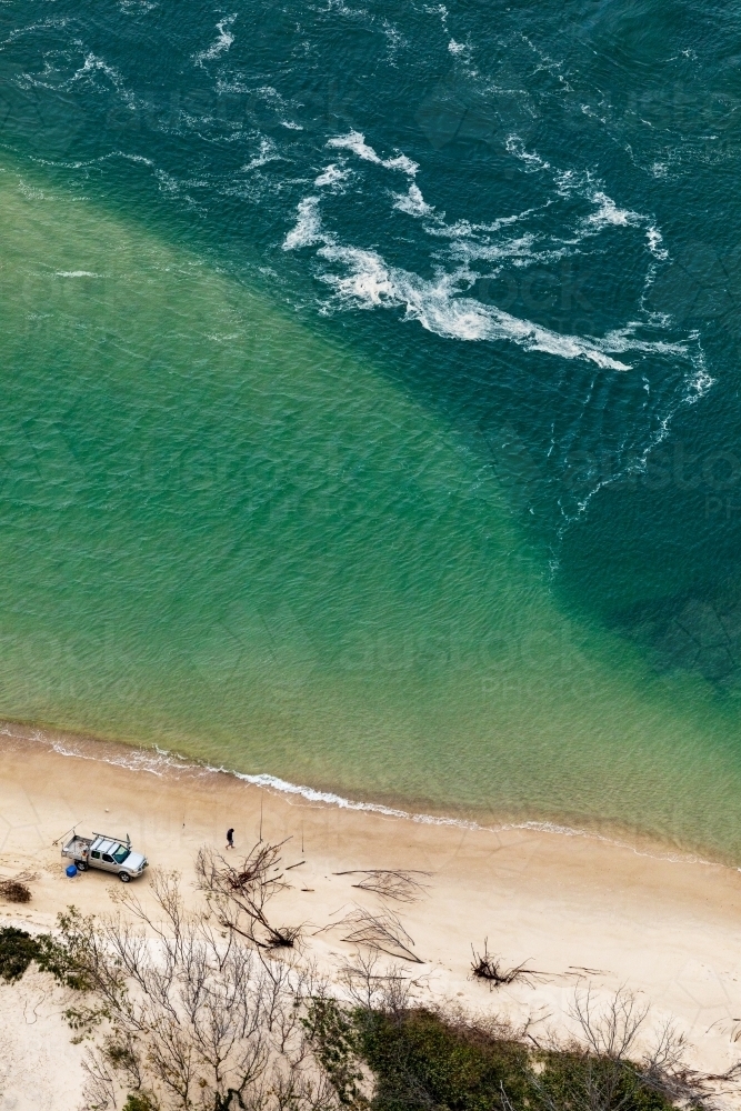 vehicle parked on beach and man beach fishing - Australian Stock Image
