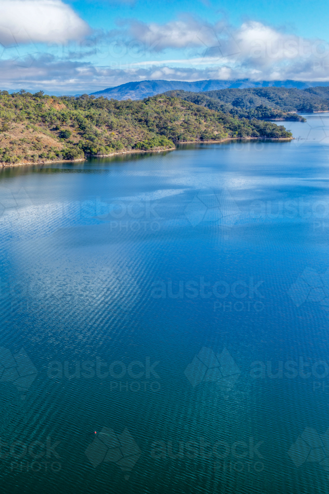 Vertical Aerial view of Glenbawn Dam  leading towards the surrounding mountains - Australian Stock Image