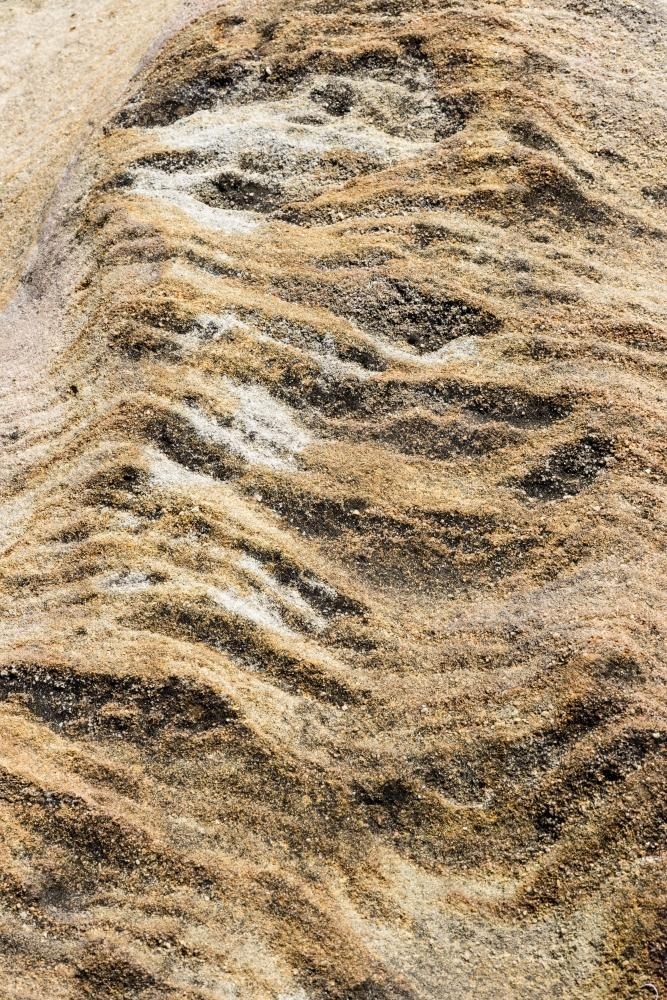 Vertical closeup of heavily textured and striated yellow and brown rock - Australian Stock Image