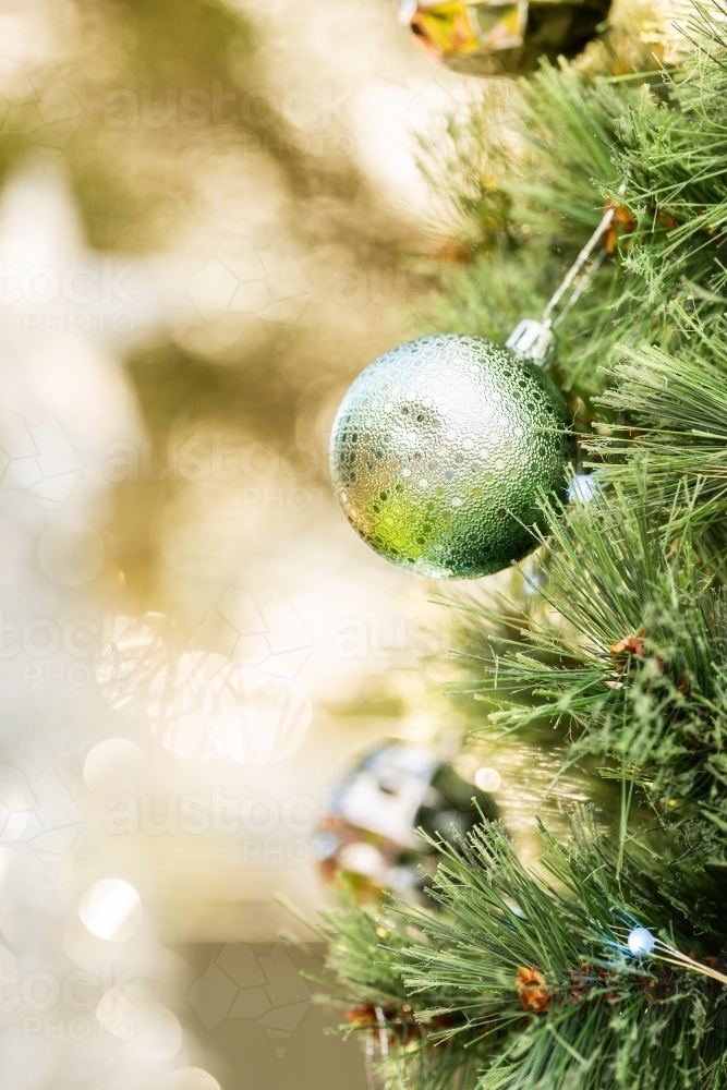 Vertical image of Christmas baubles on tree with bokeh copy space - Australian Stock Image
