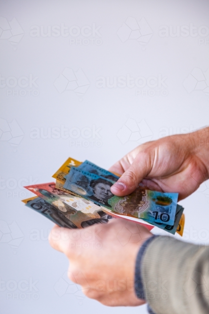 Vertical image of man with australian currency notes in hands - Australian Stock Image