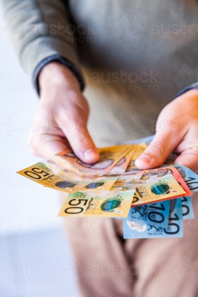 Vertical image of man with australian currency notes in hands - Australian Stock Image