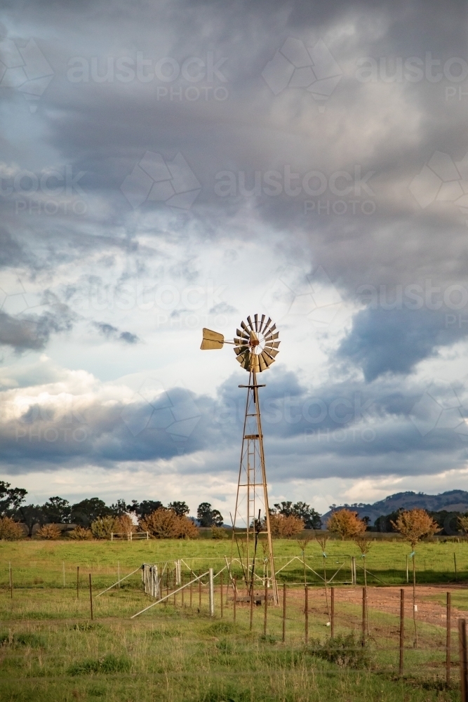 Vertical image of old windmill on rural farm on cloudy day - Australian Stock Image