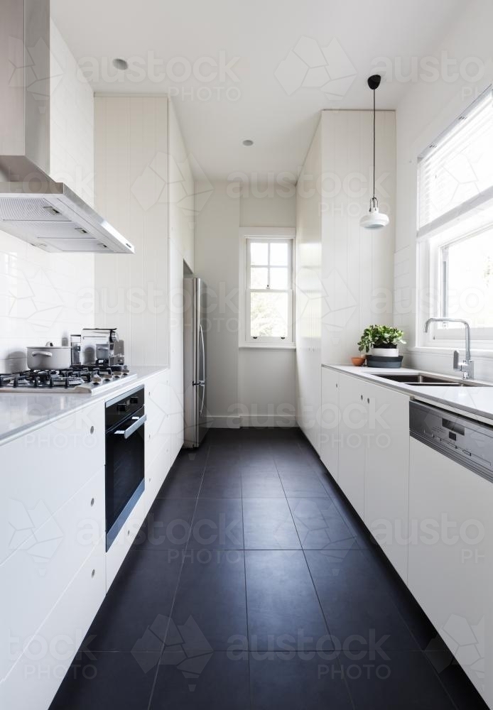 Vertical of a long galley style monochrome newly renovated kitchen - Australian Stock Image