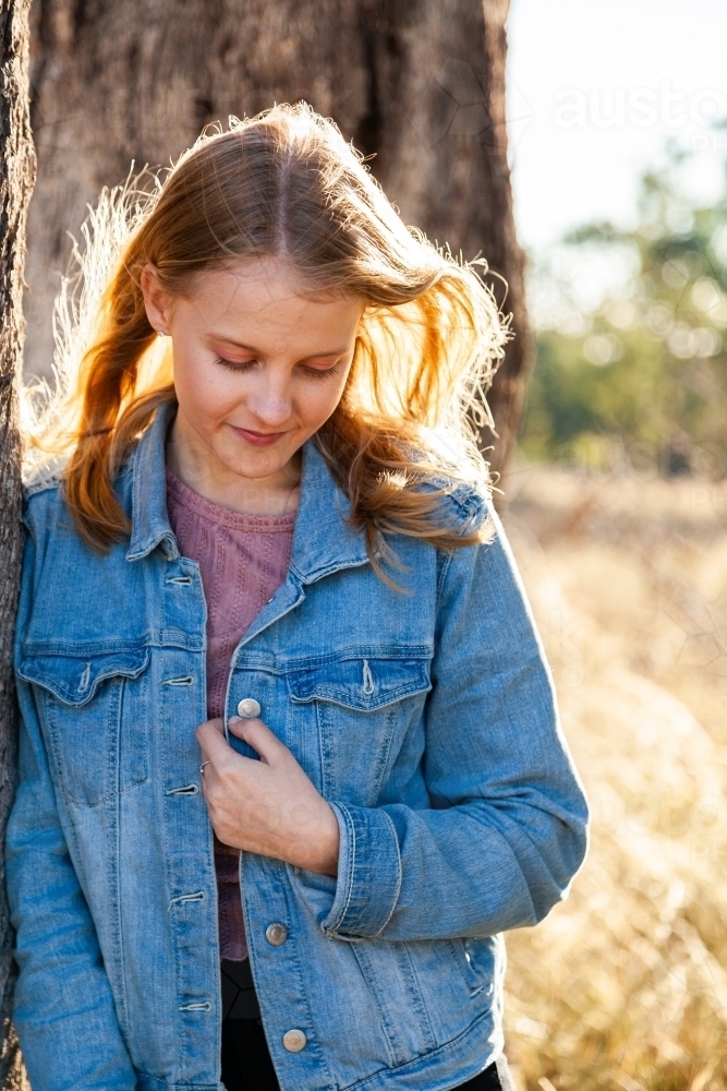 Vertical portrait of a teen girl looking down - Australian Stock Image