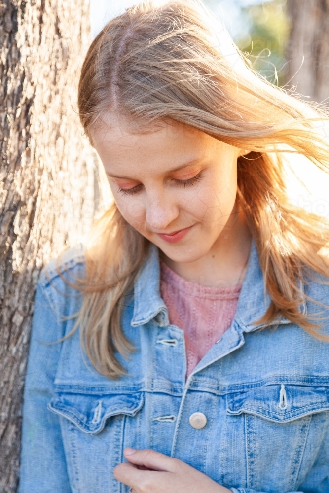 Vertical portrait of a teen girl looking down - Australian Stock Image