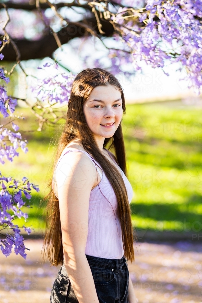 vertical portrait of happy young teen outside wearing purple - Australian Stock Image