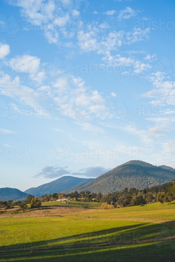 Vertical shot of a hill and mountains with trees on a sunny day - Australian Stock Image