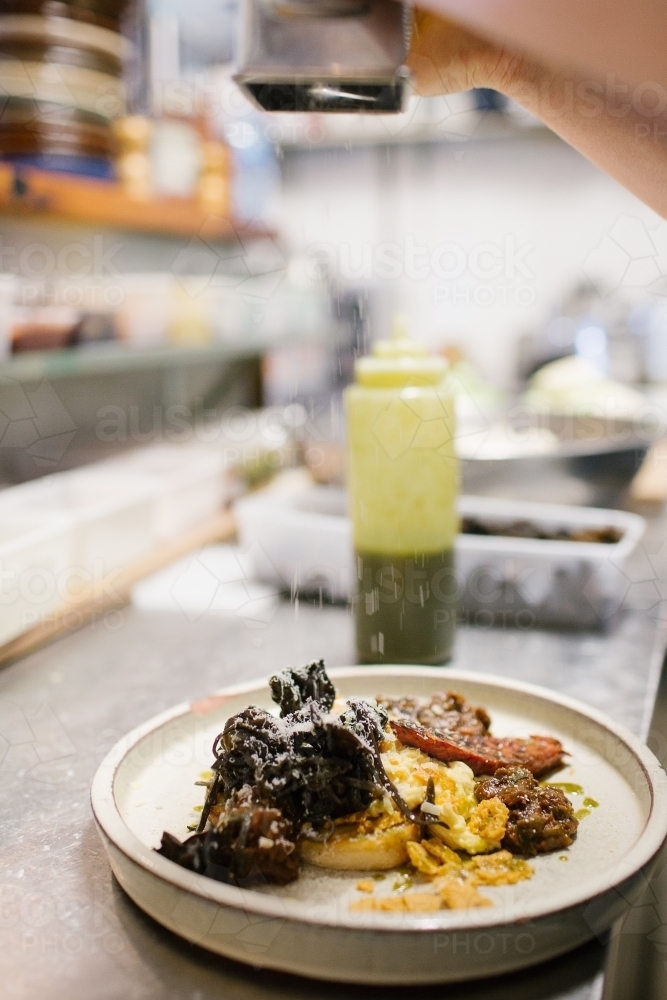 Vertical shot of a plated dish sprinkled with some grated cheese - Australian Stock Image