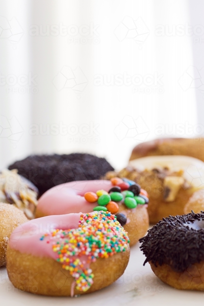Vertical shot of pink, and black topped donuts - Australian Stock Image